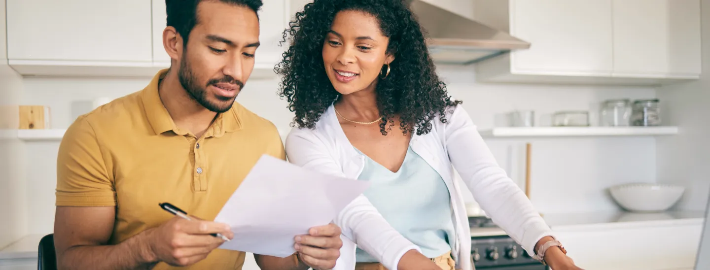 Couple planning finances with documents and a laptop 