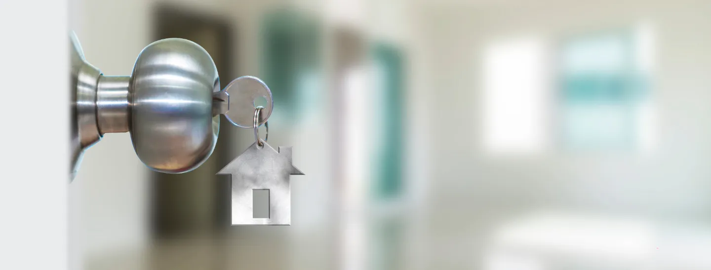 Key with house key chain hanging from door lock