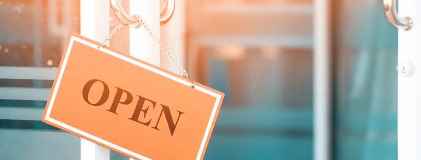 Open for business sign hanging on the door. 